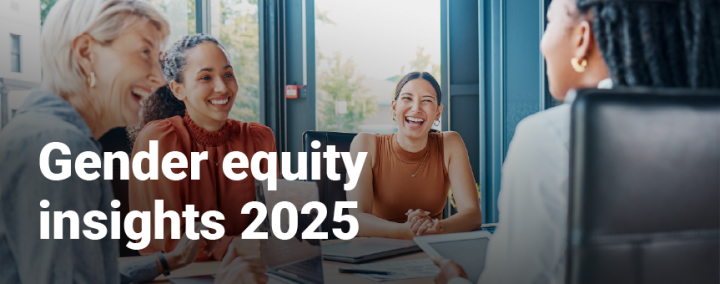 Four women sitting around a desk, smiling and laughing. White text reads Gender equity insights 2025