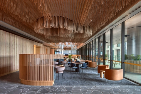 A professionally-captured image showing the entrance to the Melbourne office of Lander and Rogers. The space features lots of smooth curves, chairs and wood panel beams.